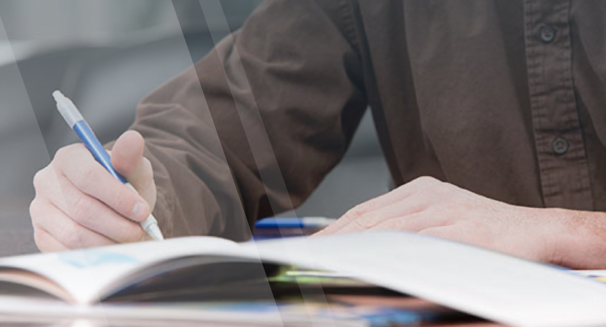 A man in brown shirt is writing in a notebook with a blue mechanical pencil - File a Complaint